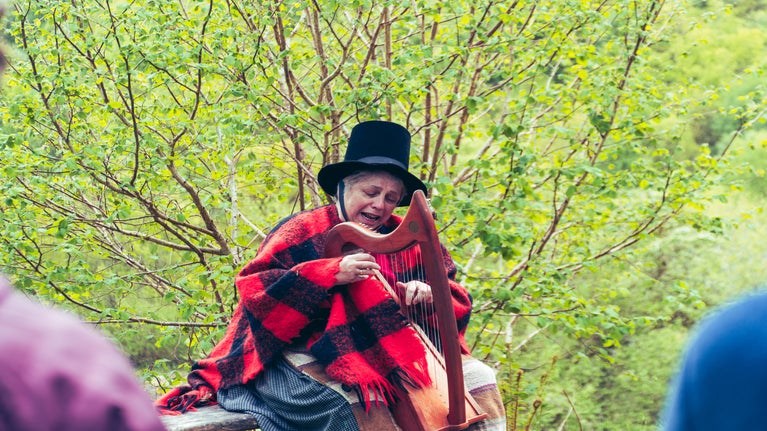 Llun o Mair Tomos Ifans yn perfformio yn ystod digwyddiad diwrnod agored yn Nhŷ Mawr Wybrnant